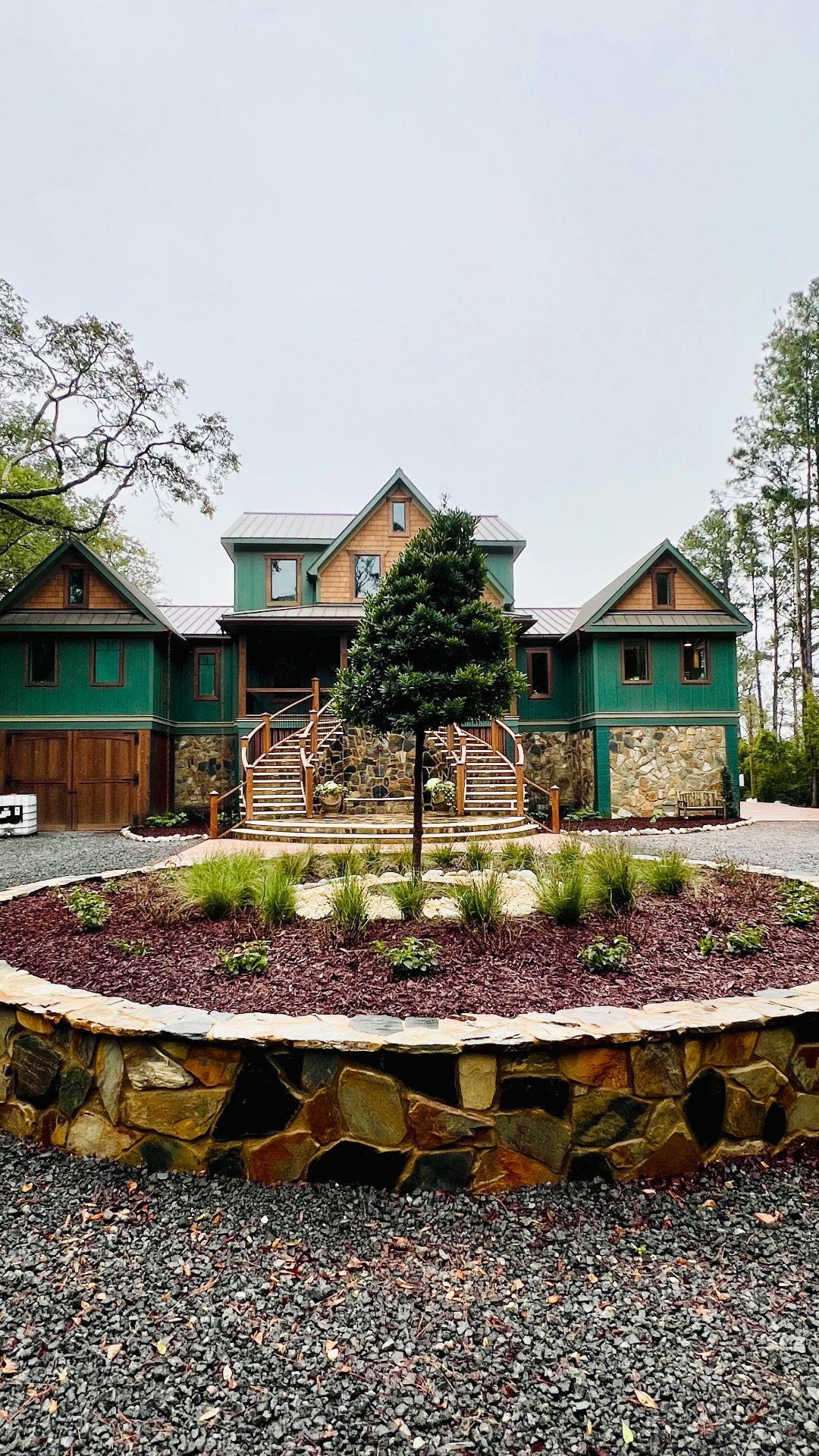 Circular drive island with ornamental grasses and a standard topiary — private estate.